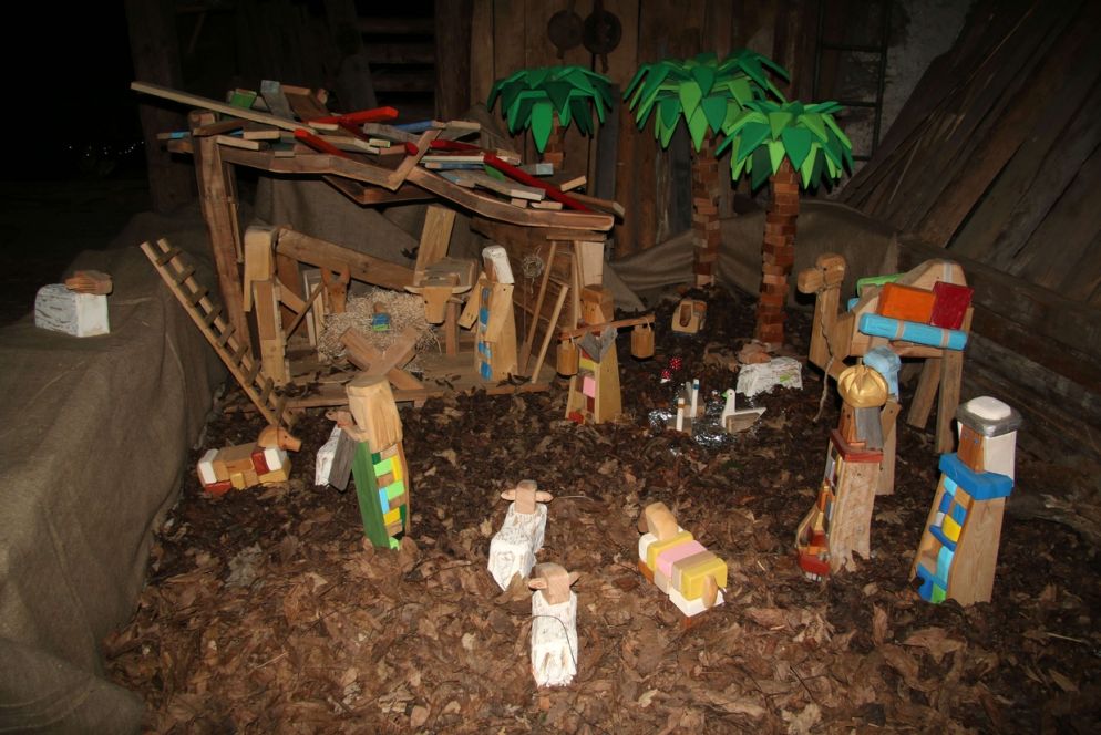 Torniamo come bambini” di Gabriele Maffei Un presepe tradizionale costruito con pezzi di legno dipinti e modellati.
