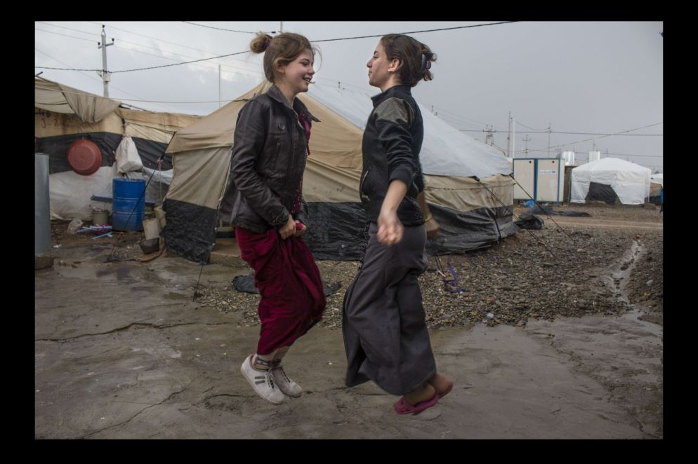 Nell'agosto 2014 oltre 400mila componenti della comunità yazida hanno dovuto abbandonare le loro case mentre Daesh conquistava, devastandole, ampie estensioni di territorio iracheno. Molti di loro sono stati fatti prigionieri e giustiziati, migliaia di donne e bambini sono stati ridotti in schiavitù. Chi è riuscito a fuggire si è rifugiato sulle montagne di Sinjar, per poi raggiungere i campi profughi della regione del Kurdistan iracheno. Il campo profughi di Khanke – il luogo dove sono ospitate le ragazze che sono anche le autrici delle fotografie e da cui provengono gli stessi scatti – ospita quasi 3mila famiglie, fuggite dalla provincia irachena di Ninive. Nonostante il trauma e gli orrori a cui ha assistito, la comunità yazida ha dimostrato caparbietà e una grande capacità di reagire, di cui la mostra fotografica è un toccante esempio.