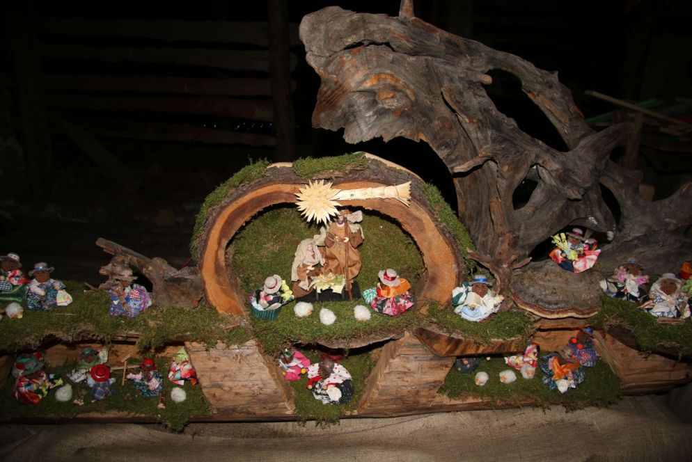 “Peruviani verso la capanna” di Pietro Panteghini. Un presepe costruito con le pigne della Val Rendena e che rappresenta il popolo peruviano che accoglie con gioia il nuovo nato. Un tronco intagliato raffigura la capanna e gli scenari circostanti