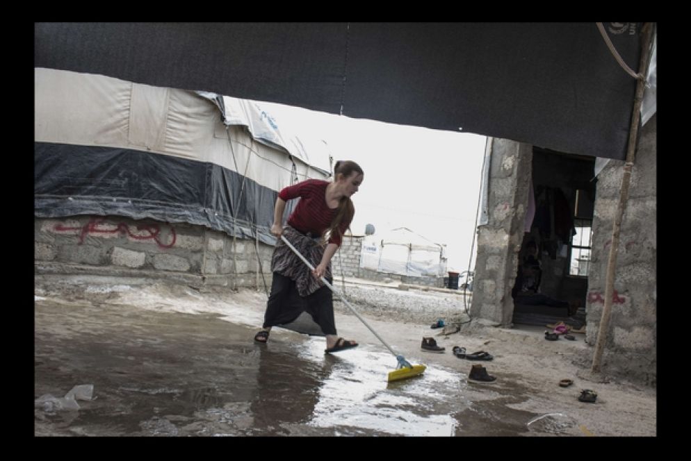 Una giovane ragazza Yazida aiuta la madre nei lavori di casa.