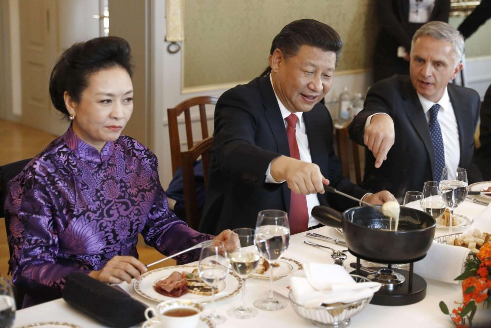 Il presidente cinese XI Jinping, con la moglie Peng Liyuan e il ministro degli Esteri svizzero Didier Burkhalter assaggia la celebre fondue au fromage a Berna (Ansa)