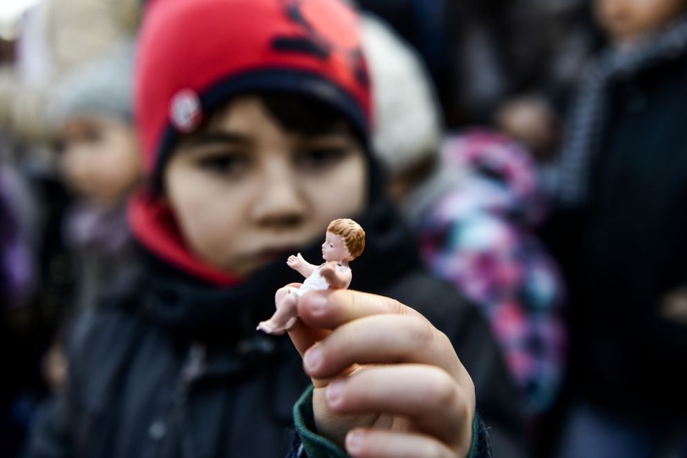 Un ragazzo con la statuetta di Gesù Bambino in mano