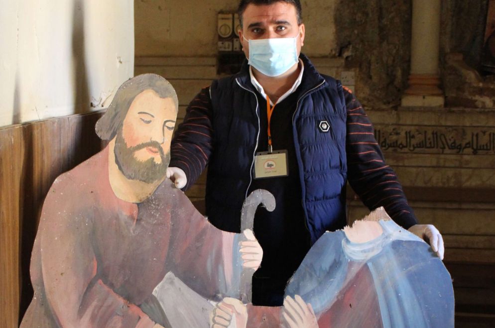 Un fedele mostra un presepe con la testa della madonna mozzata