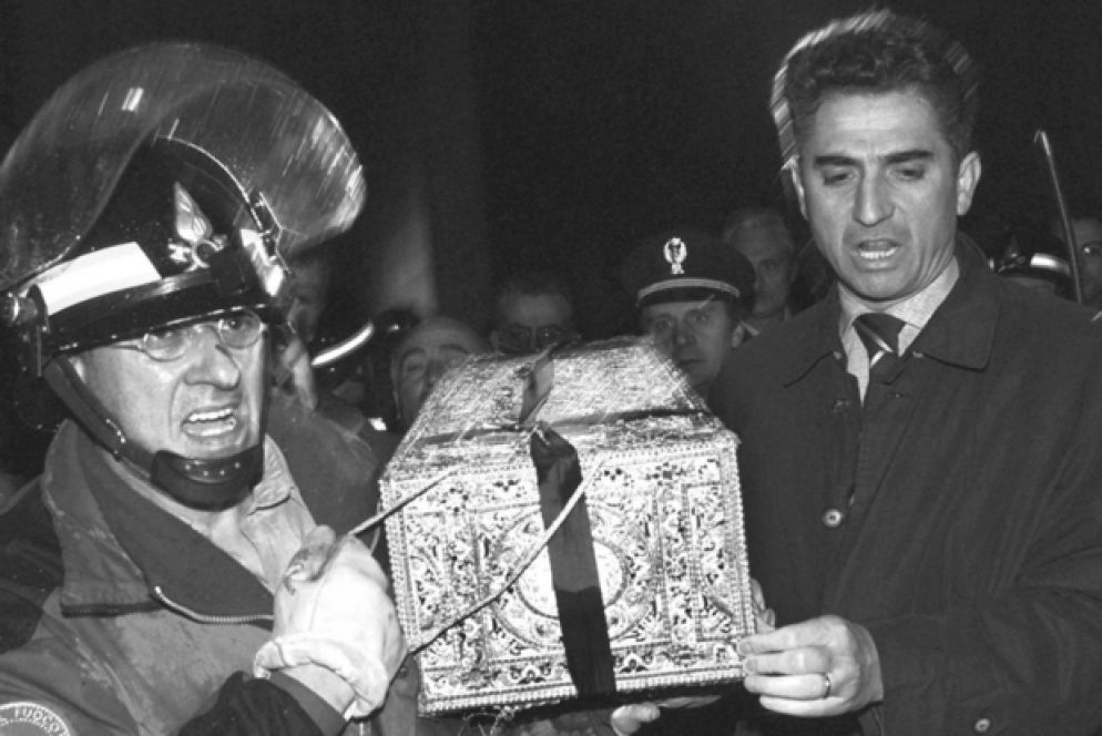 Trematore, a sinistra, mentre porta in salvo la Sindone