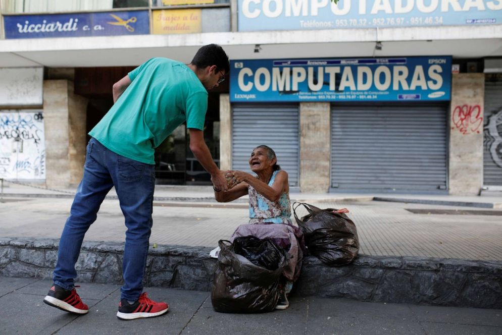 Un volontario porta i pasti ai poveri a Caracas