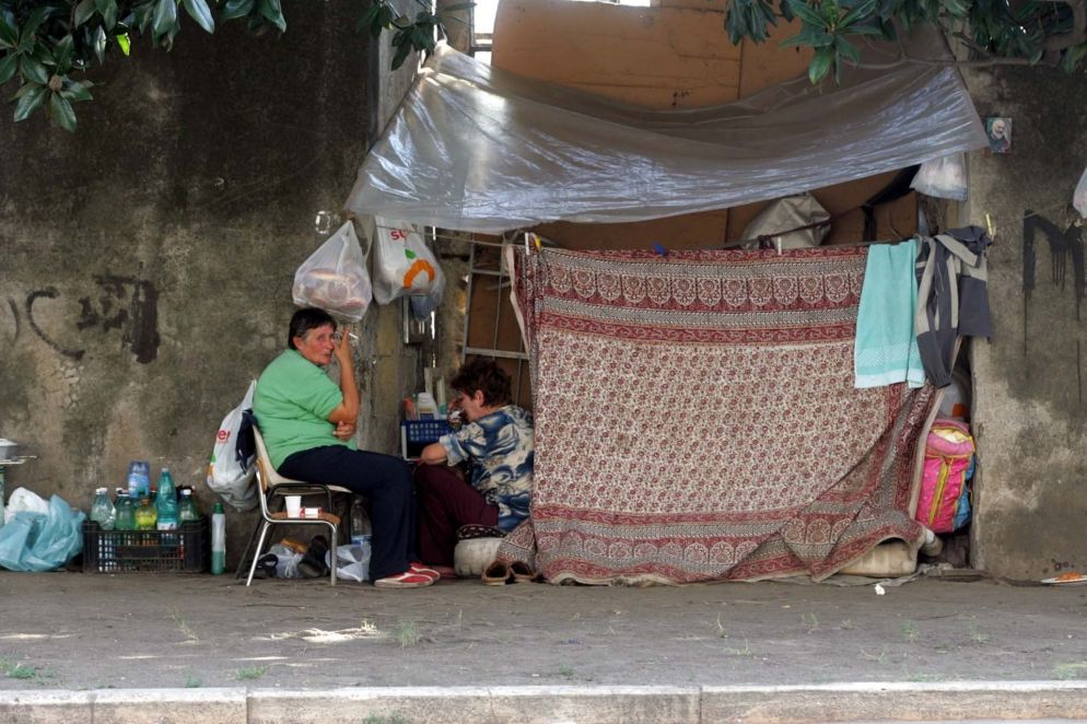 Una famiglia che abita in una baracca su un marciapiede di Napoli (Ansa)