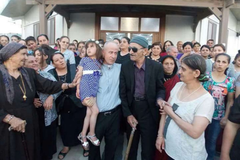 Cristina in braccio a padre Jalal Yako, con a destra i genitori della bimba