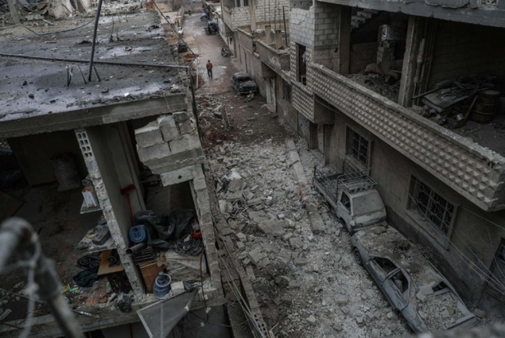 Un uomo cammina fra le macerie nel Ghouta orientale, alla periferia di Damasco (Ansa)