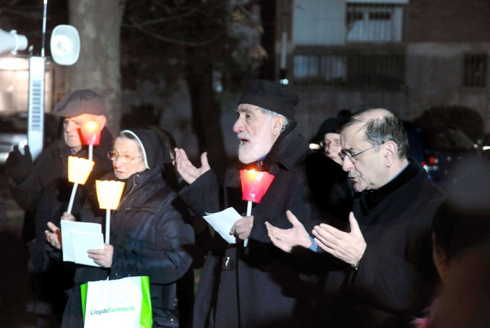 Nel cortile di via del Danubio, la preghiera sfida il gelo della sera di dicembre (Fotogramma)