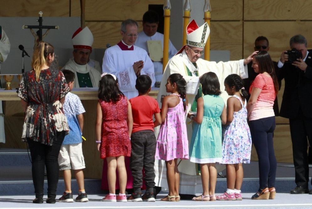 Bergoglio con un alcuni bambini durante la visita in Cile (Ansa)