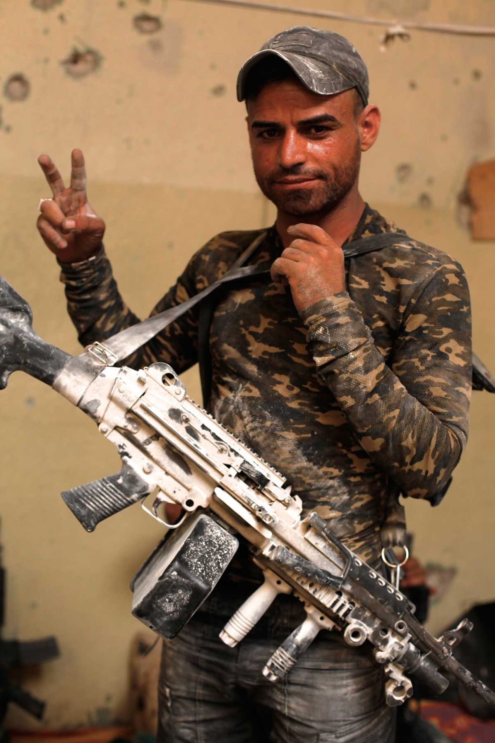 Il soldato delle Forze speciali irachene Barak Razaq al Maliki posa in segno di vittoria con il suo fucile automatico dopo la battaglia