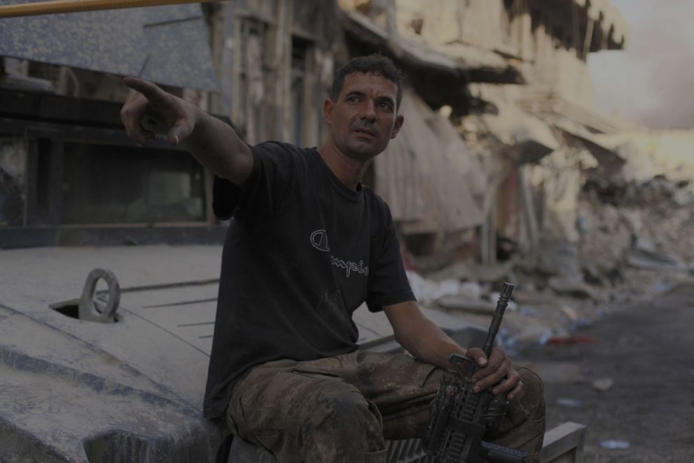 Soldato delle forze speciali irachene indica l’ultimo gruppo di case dove ancora si svolgono i combattimenti