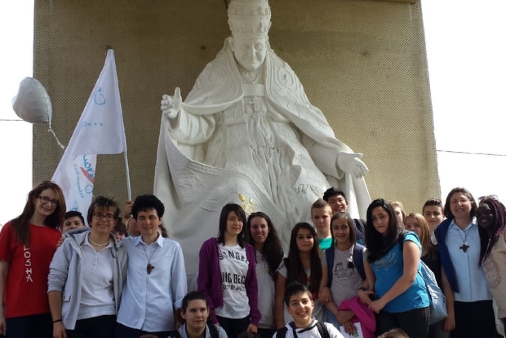 Giovani pellegrini sotto la statua che rappresnta Giovanni XXIII a Sotto il Monte