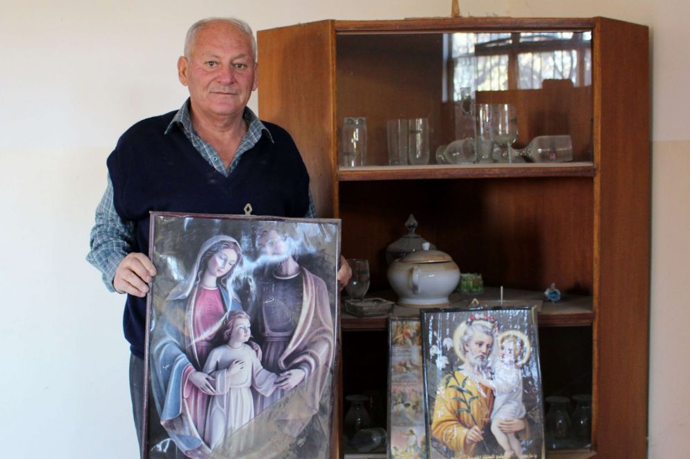 L'abitante di una casa mostra raffigurazioni religiose sopravvissute all'incendio