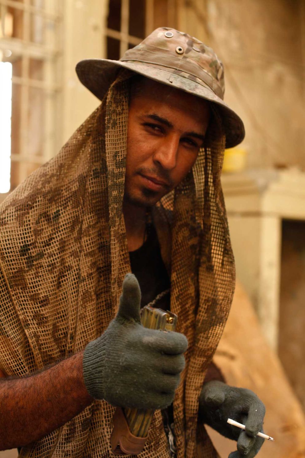 Suleiman, soldato delle forze speciali irachene, posa con in mano un accendino confiscato a un miliziano del Daesh