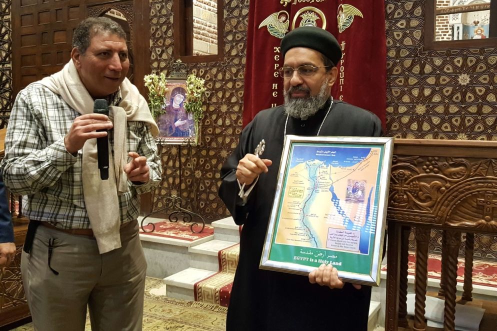 Un sacerdote copto con la carta che illustra la fuga in Egitto della Santa Famiglia (foto Gambassi)