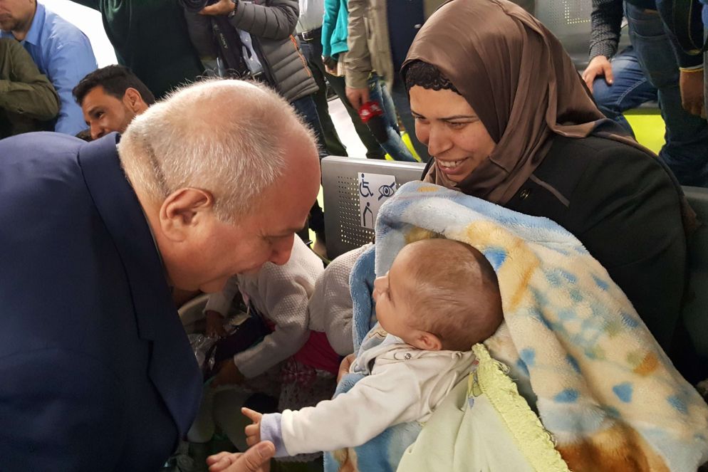 Il viceministro degli esteri Mario Giro scherza col più piccolo dei profughi (foto Luca Liverani)