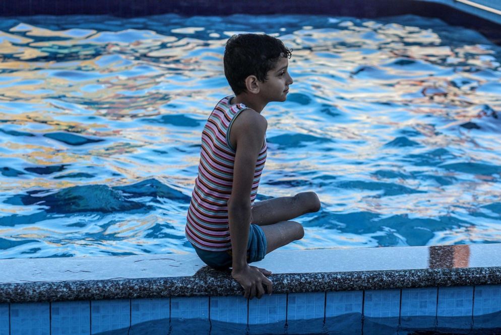 Wasem al-Shalouf, 9 anni, si riposa a bordo piscina (Ansa)
