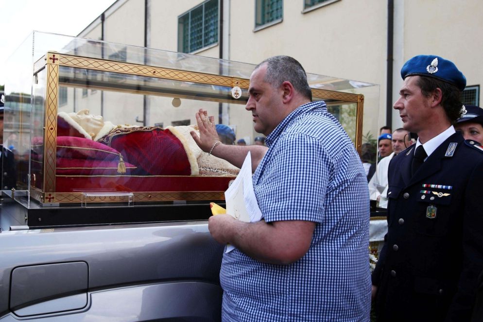 Un detenuto accarezza l'urna del santo (Ansa)