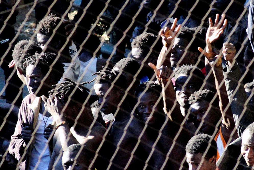 Le mani dei migranti sub-sahariani si aggrappano alla recinzione, alta 7 metri, che separa il Marocco dall'enclave spagnola di Ceuta (Ansa)