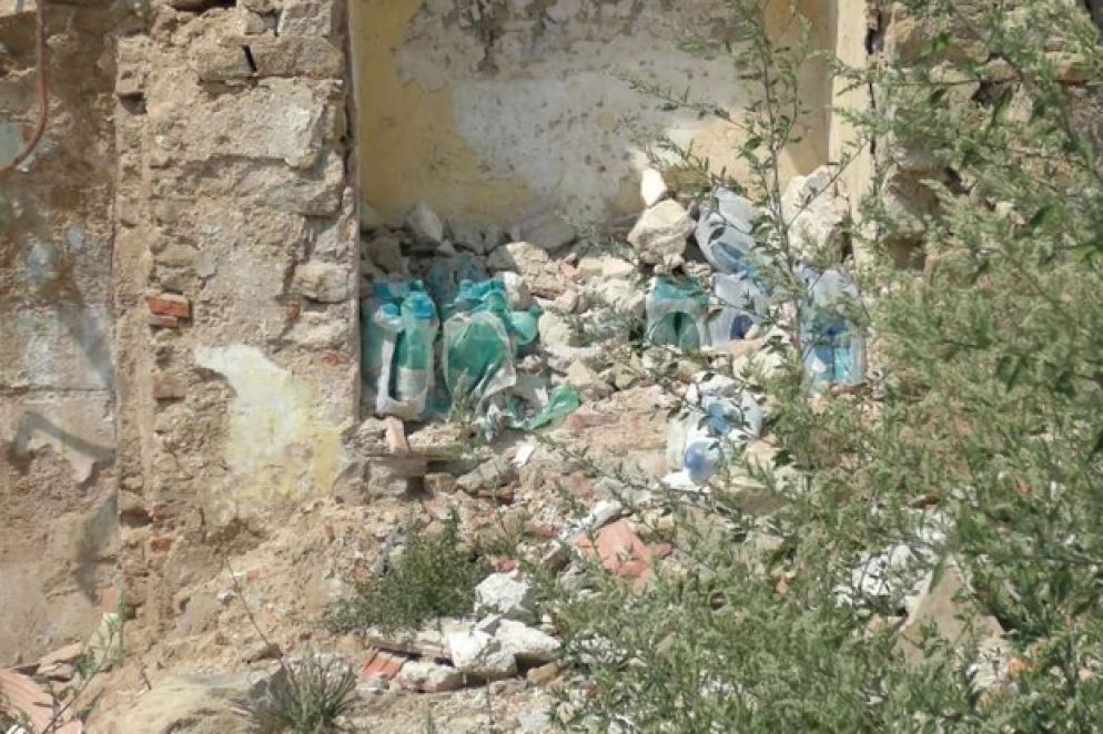 A sinistra, bottiglie d’acqua ancora oggi accatastate in una nicchia di quel che resta d’un negozio di alimentari ad Accumoli