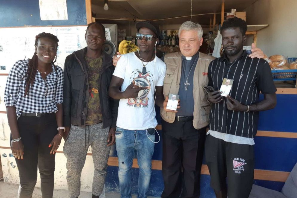 Il cardinale Konrad Krajewski, Elemosiniere di papa Francesco, con alcuni migranti del ghetto di Borgo Mezzanone nel Foggiano (foto Mira)