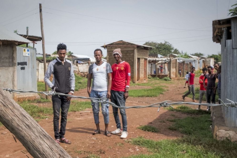 I NUMERI Il grande esodo eritreo nella confinante Etiopia inizia dal 2000, all’indomani dell’accordo di Algeri che sanciva il cessate il fuoco fra Asmara e Addis Ababa e l’inizio della “Guerra fredda” fra le due ex colonie italiane. Ad oggi, secondo i dati dell’Acnur, si registrano in Etiopia circa 130mila rifugiati eritrei, concentrati soprattutto nel Tigrai, regione confinante per 911 chilometri con l’Eritrea e a questa speculare per lingua e cultura. Dal 2004 la media di eritrei che fuggono verso l’Etiopia è di 2.300 persone al mese, il 39% sono bambini e di questi il 25% non è accompagnato. Secondo la procedura, i profughi che si affacciano in Etiopia sono registrati in uno dei dodici punti d’ingresso lungo il confine riaperto solo questo settembre dopo il disgelo fra i due paesi. Quindi sono condotti ad Endabaguna, hotspot dove stanziano una ventina di giorni prima di essere assegnati in uno dei quattro campi per rifugiati dell’area. Il più vecchio è Schimelba, aperto nel 2004, che oggi conta circa seimila persone. Mai Aini è il più grande con le sue quasi 2.500 baracche e i suoi circa dodici mila rifugiati, il 40% è minorenne. Adi Harush è stato fondato dal 2010, ospita undicimila eritrei di età per più di un terzo fra i 18 e i 24 anni. Il più recente dei quattro campi è Hitsats. Aperto nel 2013 conta 1333 moduli abitativi e circa undici mila rifugiati. A coordinare l’accoglienza è l’agenzia governativa etiope Arra – Administration for Refugee and Retuneer Affair –, in collaborazione con Acnur Etiopia.