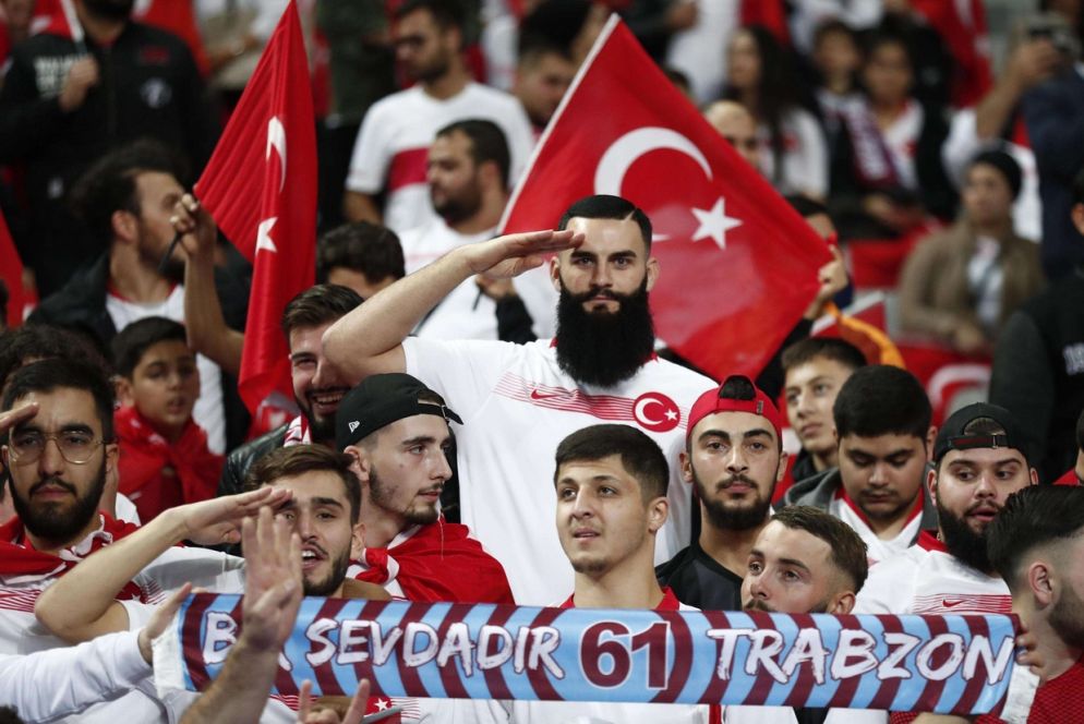 Tifosi turchi fanno il saluto militare prima dell'inizio della partita Francia-Turchia, a Parigi (Ansa)