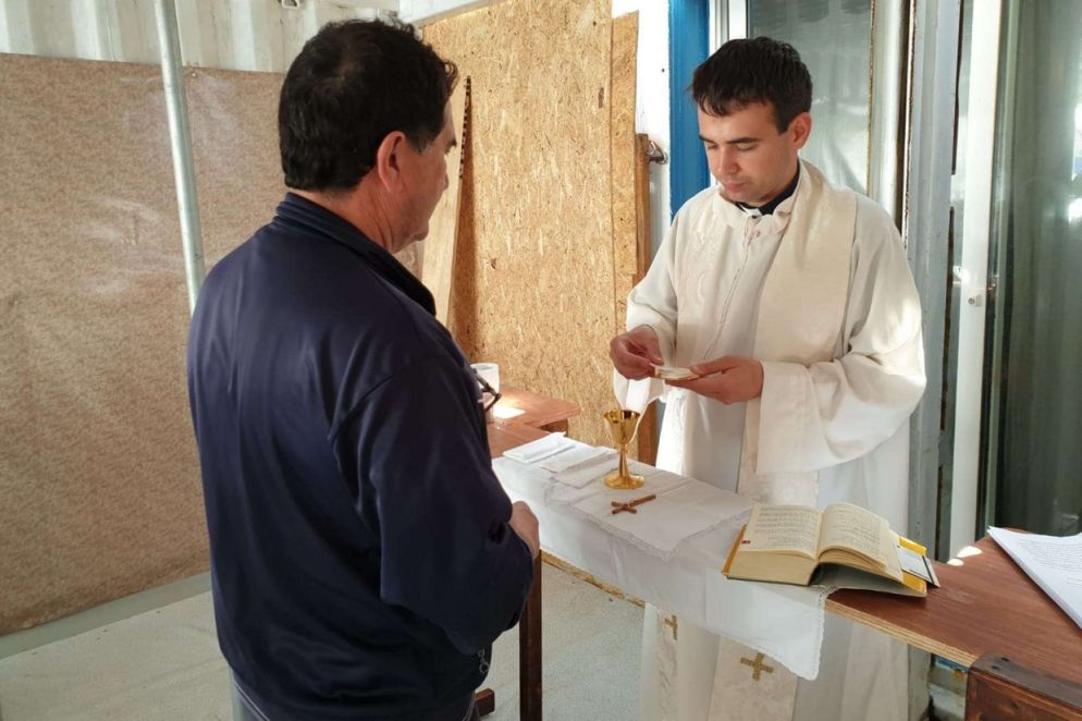 Il sacerdote mentre distribuisce l'Eucarestia al termine della Messa (Mediterranea)