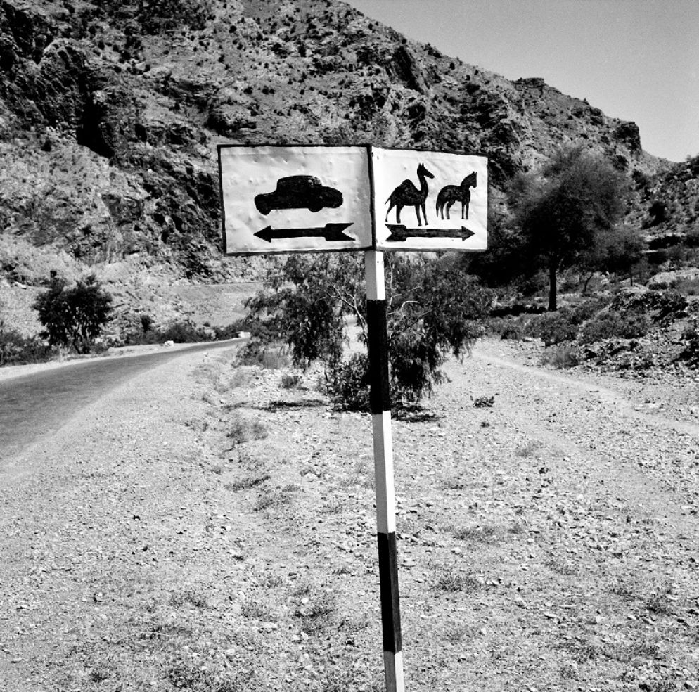 Cartello stradale vicino al Passo di Khyber dove passerà l’Autostrada Asiatica Internazionale, un progetto avviato nel 1958 dall’ONU che mira a modernizzare e collegare le strade esistenti in Asia in una rete di autostrade lunga 34.000 miglia, Passo di Khyber, Afghanistan, aprile 1964 © courtesy UN Photo/WT