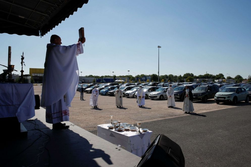 I sacerdoti hanno percorso tutte le file di auto parcheggiate per distribuire l'eucaristia, rigorosamente consegnata nelle mani dopo un passaggio con il disinfettante idroalcolico