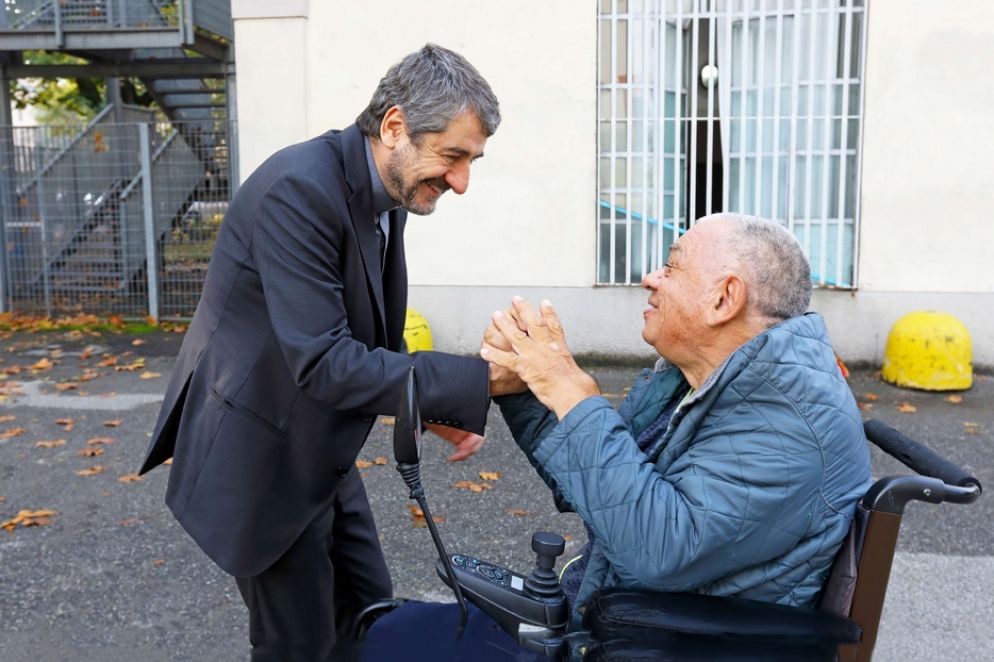 Don Marco Bove chiacchiera con un ospite della Sacra Famiglia