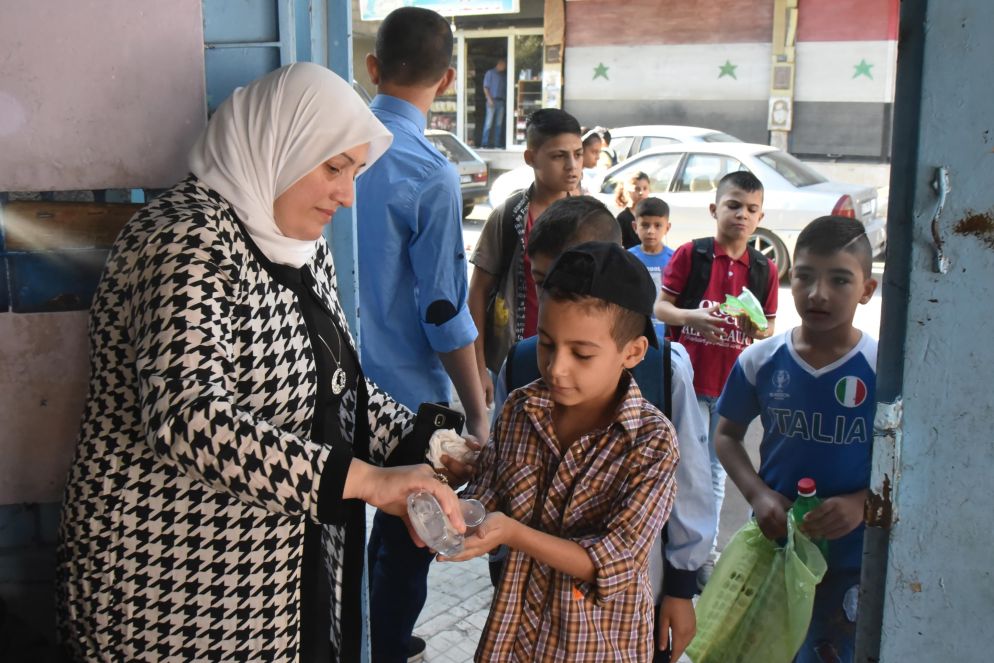 Studenti si disinfettano le mani prima di entrare in classe a Damasco, in Siria. La scuola è iniziata il 5 settembre