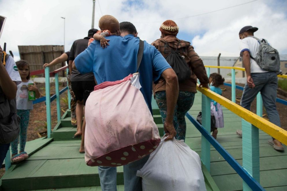 Una bimba venezuelana in braccio al suo papà in arrivo a un centro di accoglienza a Pacaraima