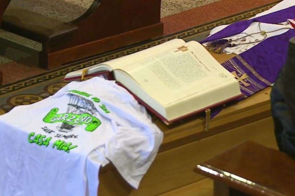 La bara di don Alfredo con il Vangelo aperto e la maglia del "suo" gruppo giovani