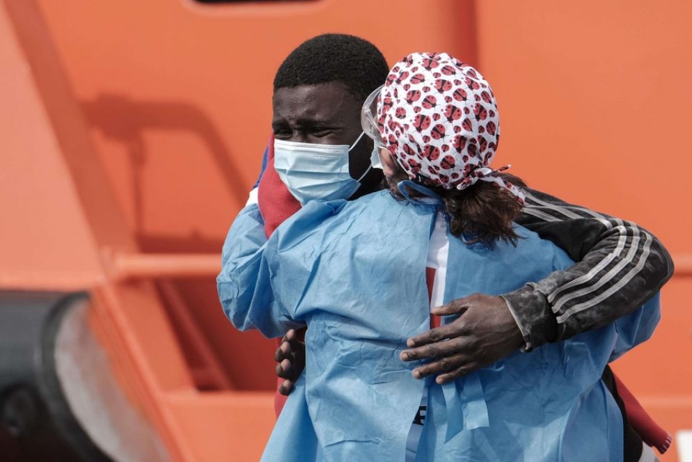 Un migrante accolto da una volontaria - Epa