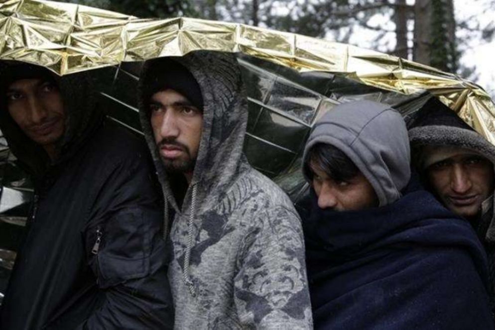 Alcuni profughi si proteggono con una coperta termica lungo la rotta balcanica - Unhcr