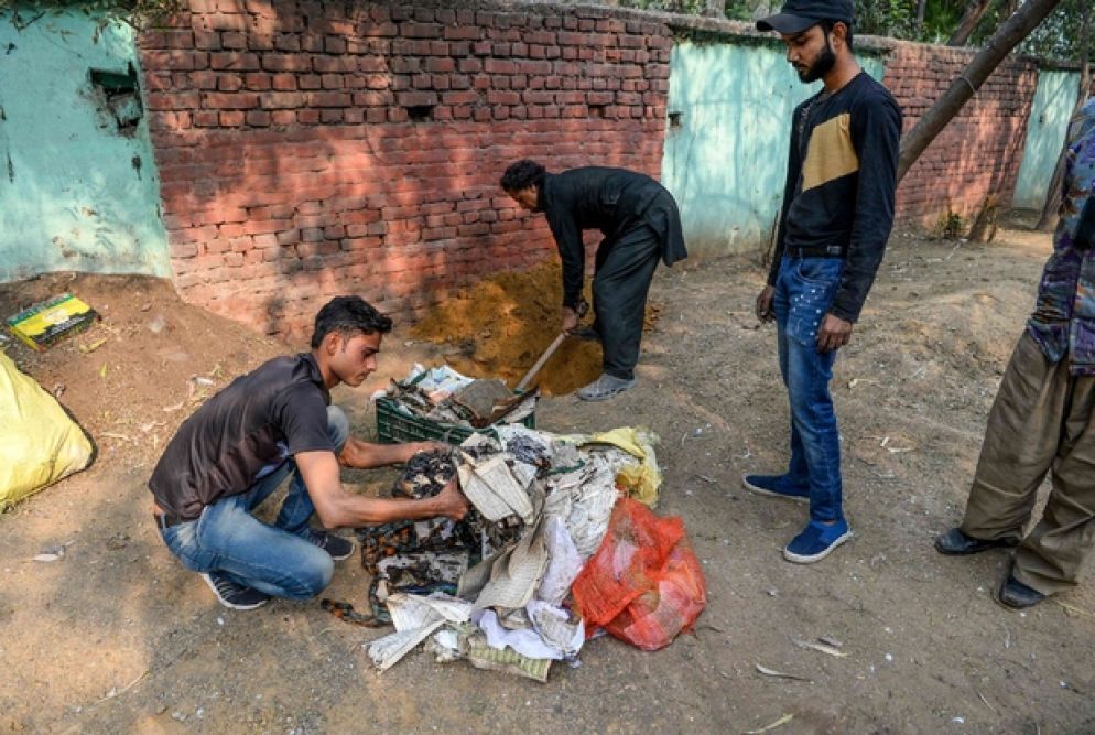 Alcuni saccheggiatori si preparano a bruciare delle copie del Corano prelevate in una moschea - Ansa