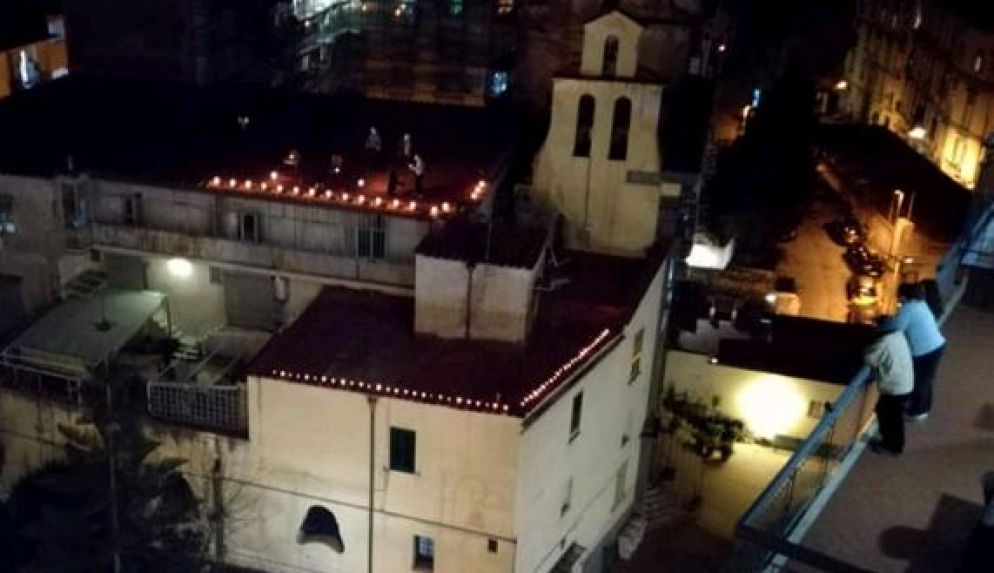 Il tetto della chiesa di Santa Maria della Salute con i sacerdoti e intorno i parrocchiani dai balconi - da facebook