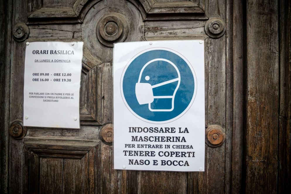 All'ingresso di una chiesa il cartello che indica l'obbligo della mascherina - Fotogramma
