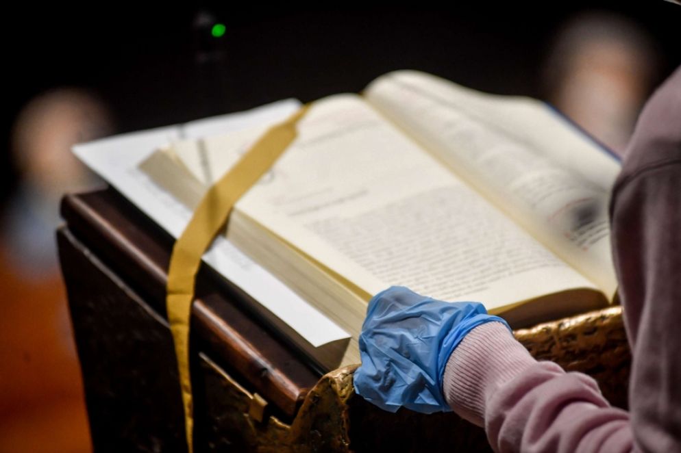 Il lettore con i guanti nel Duomo di Milano - Fotogramma