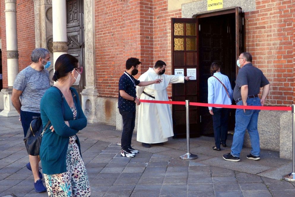 I volontari all'ingresso di una chiesa di Milano - Fotogramma