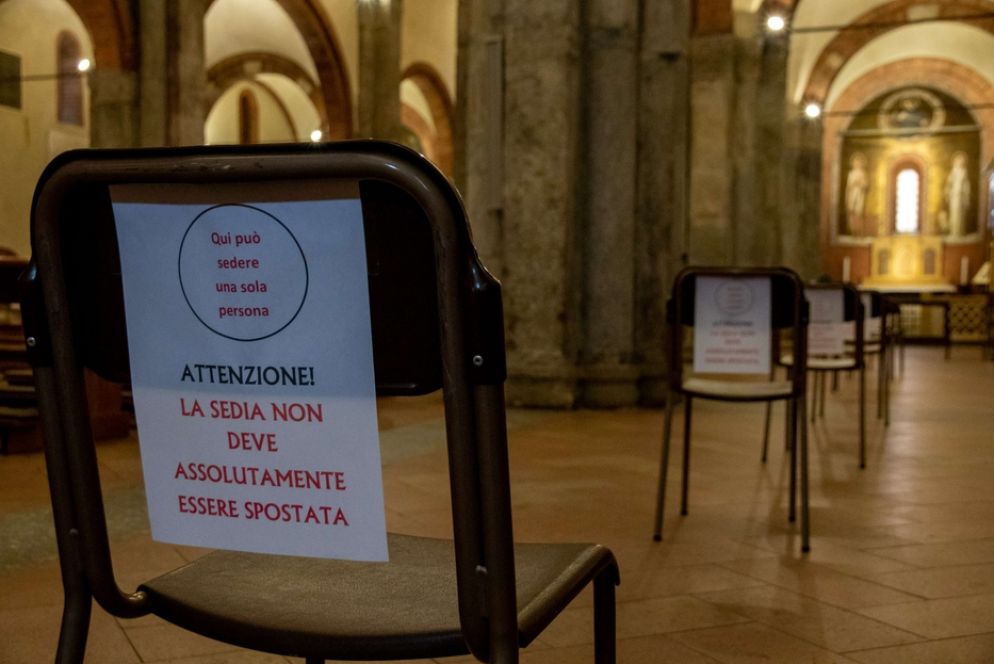 Un cartello per il rispetto delle distanze in una chiesa - Fotogramma
