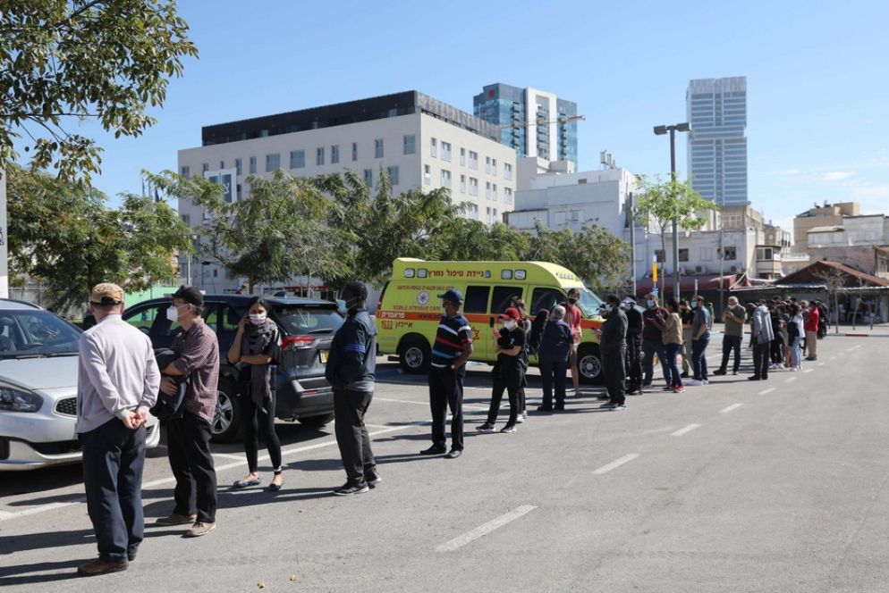 La fila che si è formata davanti alle postazioni per la vaccinazione dei migranti a Tel Aviv - Ansa