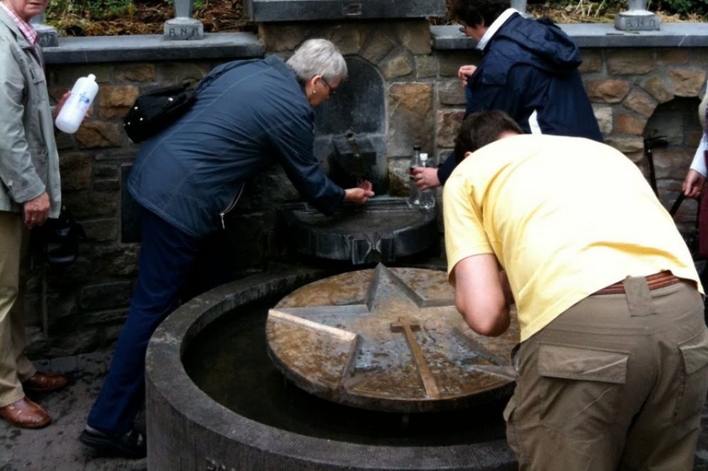 Fedeli alla sorgente presso il santuario di Banneux - Foto di archivio