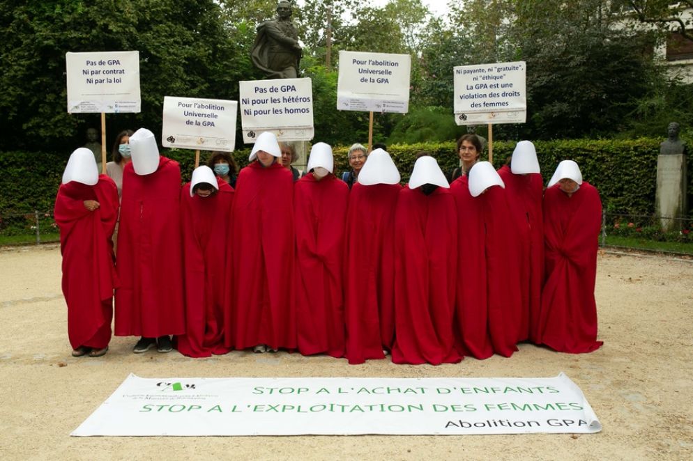 Un momento delle proteste davanti al Salone di Parigi: le attiviste della Coalizione per l’abolizione della maternità surrogata vestite in rosso come "ancelle" - Foto Cappelletti