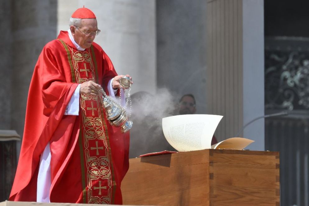 Il cardinale Re incensa la bara del Papa, mentre il vento sfoglia le pagine del Vangelo (un'immagine che ha rievocato in tutti le immagini del funerale di Giovanni Paolo II) - Ansa