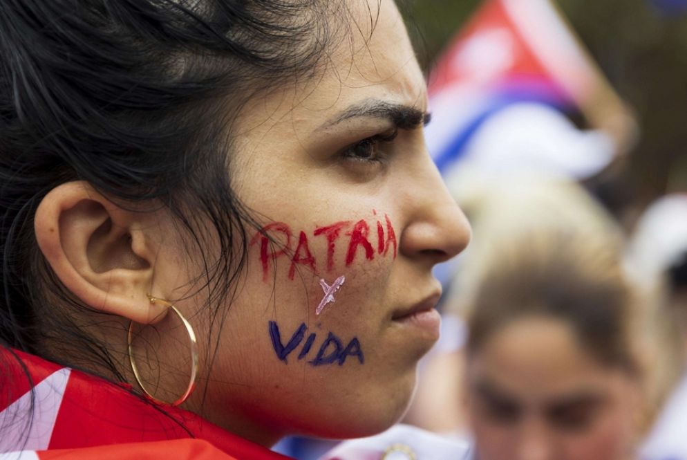 Una dimostrante con la scritta della canzone simbolo delle proteste - Ansa