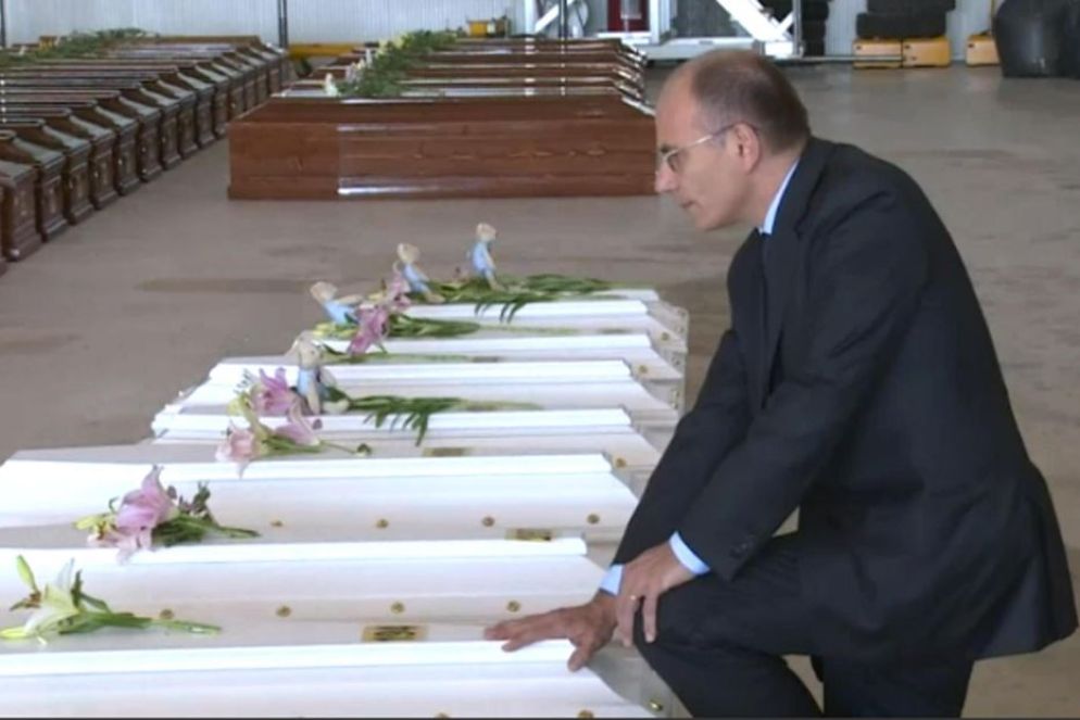 Tra loro anche bambini. Qui l'allora premier Enrico Letta in ginocchio davanti alle bare bianche, segno di un Paese addolorato