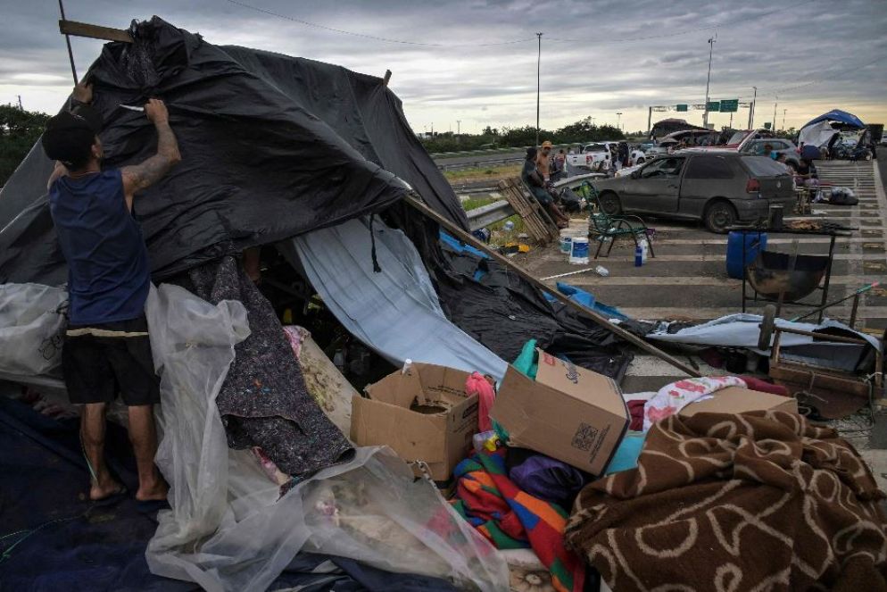 Le persone rimaste senza casa a causa dell'alluvione allestiscono un accampamento di fortuna sulla strada nel quartiere di Humaita